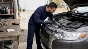 Technician closing hood after SUV oil check