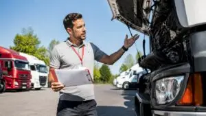Fleet manager inspecting truck engine during oil change
