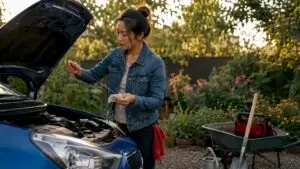 Woman checking tire pressure on commuter car