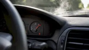 Car engine temperature gauge near red zone