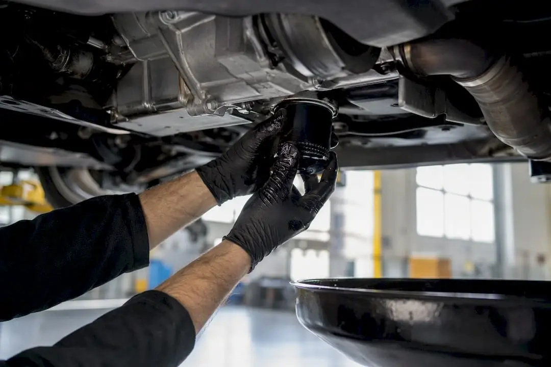 Hands removing engine oil filter