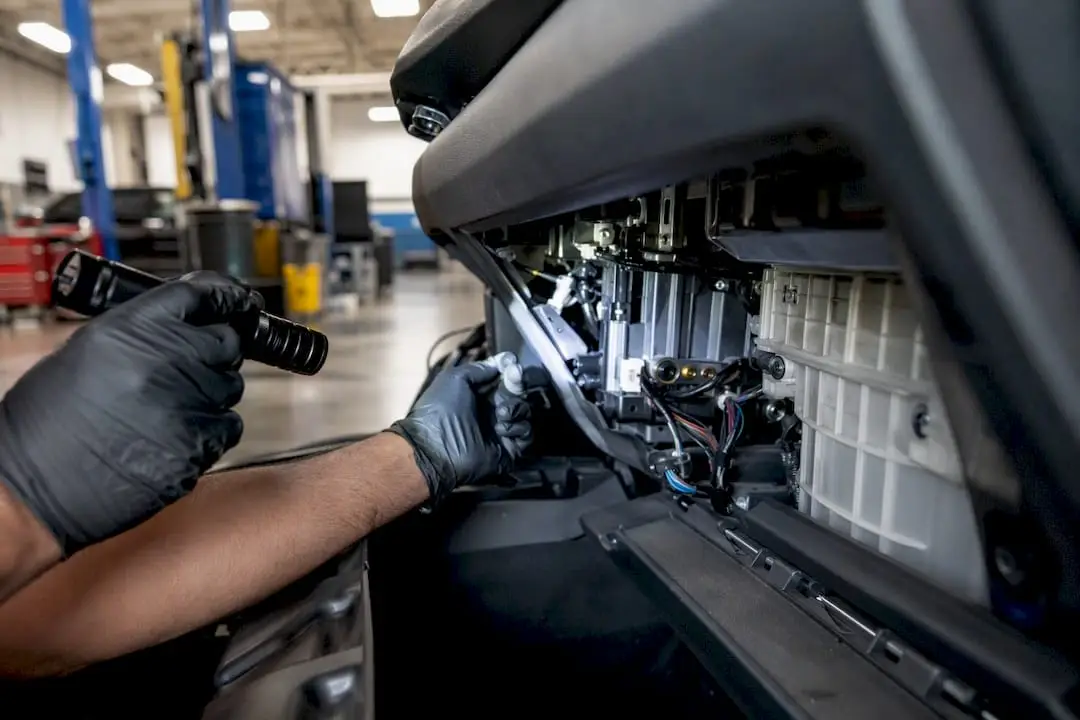 Technician inspecting car AC system hands close-up