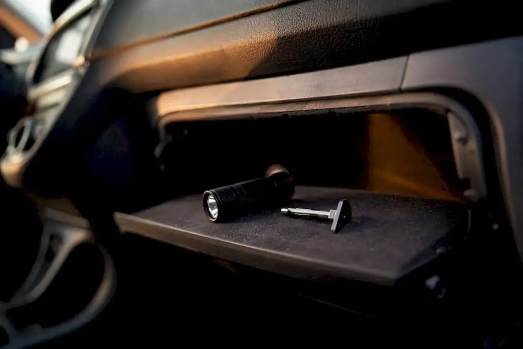Tire tread gauge and flashlight in car glove box