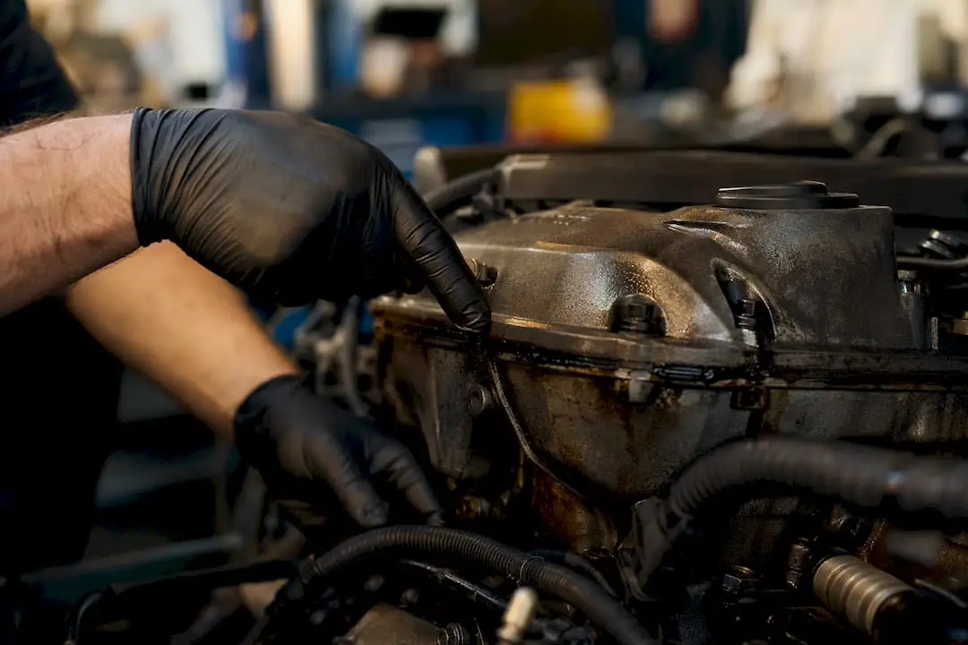 Close-up of engine valve cover gasket with oil leak