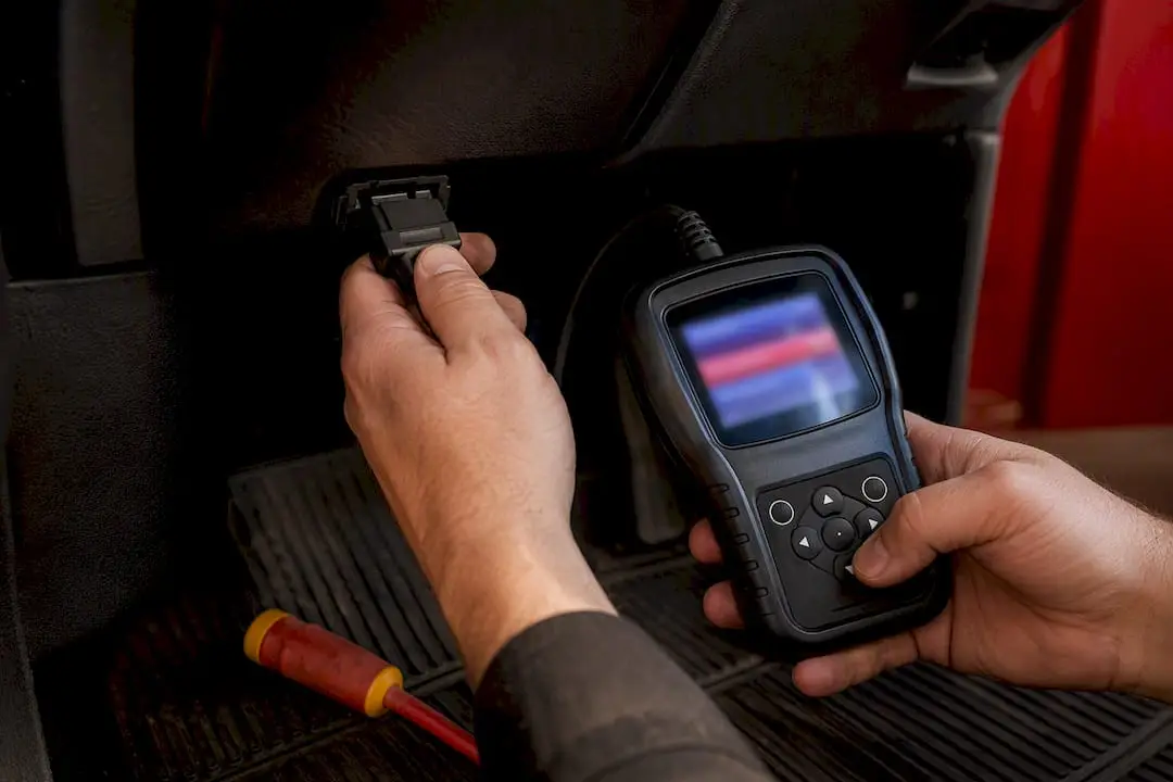 Technician connecting scanner to OBD port