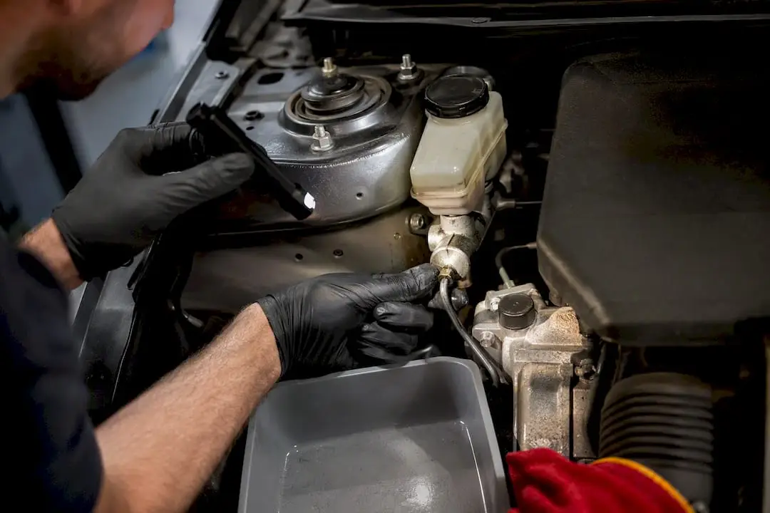Technician inspecting brake fluid and hydraulic line