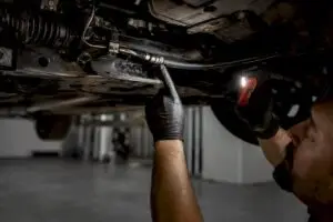 Technician inspecting steering hose for leak