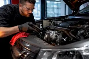 Technician diagnosing an automotive AC compressor