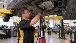 Technician servicing automatic transmission fluid