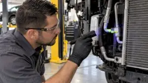 Technician inspecting fluorescent dye on an AC line